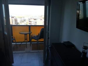 a room with a balcony with a table and chairs at ARANYHÍD APARTMAN in Siófok