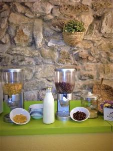 a green shelf with food items on a stone wall at Mas Colom in Sant Joan les Fonts