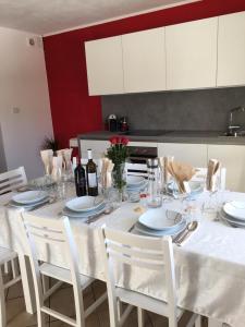 Apartment Peskoller في فالزيس: طاولة بيضاء مع كراسي بيضاء ومطبخ ابيض