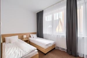 1 dormitorio con 2 camas y ventana en Patra, en Varsovia