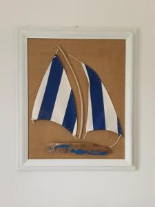 a painting of a boat with blue and white sails at Prima Fila in Lerici