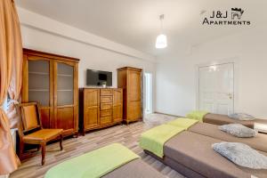 托伦J&J Apartments Łazienna 30 - 10的一间卧室设有两张床、一台电视和一把椅子