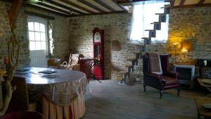 a living room with a table and chairs at La Ferme Blanche in MÃ©nil-Vin