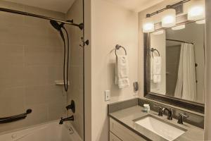 a bathroom with a sink and a tub and a mirror at 312 Water Street Inn in Boyne City +11 photos