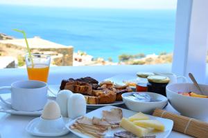a breakfast table with a plate of food and a drink at Vega Apartments in Tinos Town