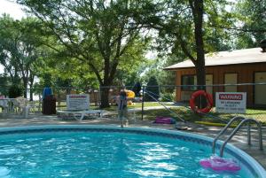 a man is standing next to a swimming pool at Lewis & Clark Resort in Yankton