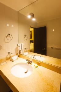 baño con lavabo y espejo grande en Casa Suyay, en Lima