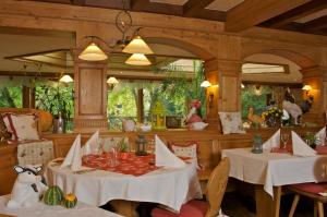 a dining room with two tables with white table cloth at Hotel Restaurant Le Petit Kohlberg in Lucelle