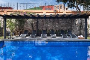 a group of chairs next to a swimming pool at Matian Hotel Boutique in Tequisquiapan