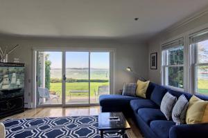 a living room with a blue couch and a sliding glass door at 115 Water Street Inn in Boyne City