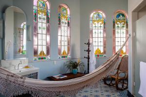 a room with a hammock and stained glass windows at Guesthouse Bianca in Rio de Janeiro