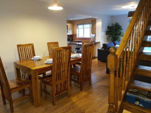 una cucina e una sala da pranzo con tavolo e sedie in legno di Moorland House a Syston