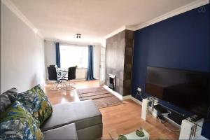 a living room with a couch and a blue wall at 3-Bedroom Comfy Home in Solihull in Solihull