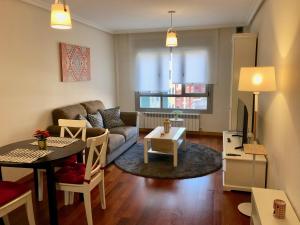 uma sala de estar com um sofá e uma mesa em Apartamento Europa Prados - Atenea em Oviedo