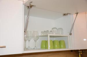 a cabinet filled with glasses and wine glasses at Green Island in the downtown with free parking in Debrecen