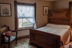 una camera con un letto e una sedia e una finestra di Prairie Creek Inn a Walton