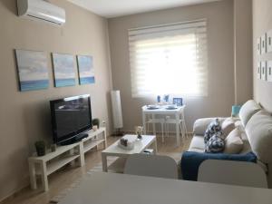 salon z kanapą i telewizorem w obiekcie Apartamento DELUXE Benalmádena w mieście Benalmádena