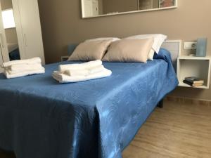 niebieskie łóżko z ręcznikami na górze w obiekcie Apartamento DELUXE Benalmádena w mieście Benalmádena