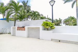 奧喬里奧斯的住宿－Ocho Rios Beach Front Condos，白色的建筑,有盆栽和街灯