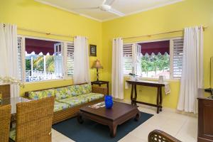 奧喬里奧斯的住宿－Ocho Rios Beach Front Condos，客厅配有沙发和桌子