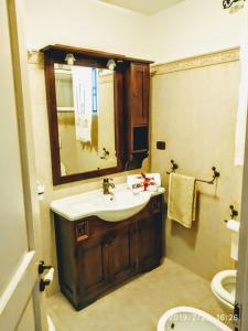 a bathroom with a sink and a mirror and a toilet at Le Tre Volte a Stella - Family Borgo Relax e Mare in Felline +18 photos