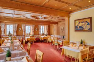 - un restaurant avec des tables et des chaises dans une salle dans l'établissement Berg-Spa & Hotel Zamangspitze, à Sankt Gallenkirch