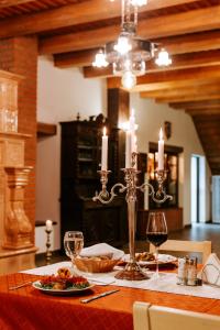 a dining room table with two candles and wine glasses at Conacul Nagy in Coşeni