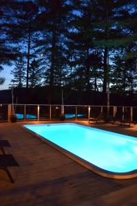 a swimming pool on a deck at night at Auberge le Cosy in La Conception