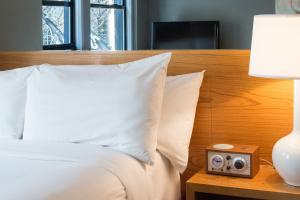 un letto con testiera in legno e un orologio su un tavolo di Hotel Max a Seattle Altre 37 foto