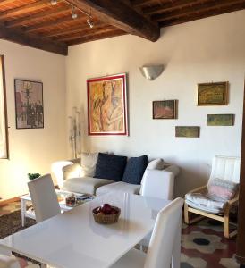 un soggiorno con divano, tavolo e sedie di Casa Emilio a Siena