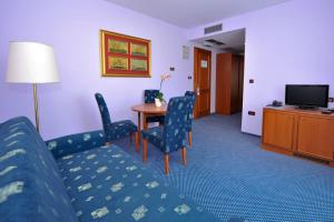 um quarto de hotel com um sofá, cadeiras e uma mesa em Villa Kastel em Povljana