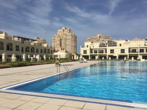 a large swimming pool with buildings in the background at Haven Studio Apartments in Ras al Khaimah