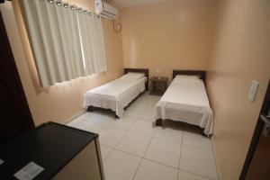 ein Krankenhauszimmer mit 2 Betten und einem Fenster in der Unterkunft Mosaico Hotel in Dianópolis