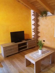 ein Wohnzimmer mit einem TV und einem Couchtisch in der Unterkunft maison Venoir2 in Aymavilles