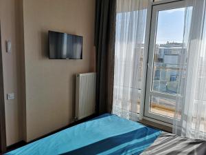 a bedroom with a bed and a large window at Элитная квартира в Аркадии с видом на море 26 Жемчужина in Odesa