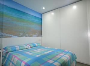 ラスパルマス・デ・グランカナリアにあるPlaya Chica en Las Canterasのベッドルーム1室(壁に絵画が描かれたベッド1台付)