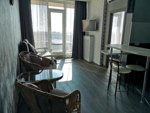 a room with chairs and a table and windows at Элитная квартира в Аркадии с видом на море 26 Жемчужина in Odesa