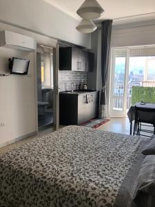Cet appartement comprend une chambre avec un lit et une cuisine avec une table. dans l'établissement Ottieri Apartment Napoli Room&Kitchen with Panoramic View, à Naples
