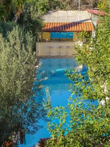 a swimming pool in the middle of a yard with trees at St. Thomas Bed and Breakfast in Paianía