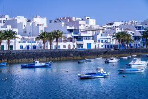a group of boats in a body of water with buildings at Rooms & Suites Loft 2G Deluxe Edition Arrecife in Arrecife