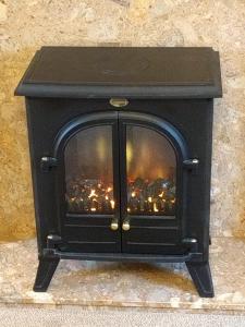 a black fireplace with a view of a city at Bridge of Bennie Cottage in Banchory