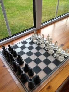 Um tabuleiro de xadrez está sentado no peitoril da janela. em Bridge of Bennie Cottage em Banchory