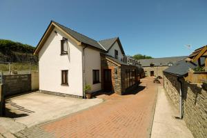 uma casa branca com um passeio de tijolos ao lado de um edifício em The Workshop em Aberystwyth