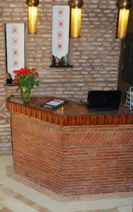 a bar with a laptop on a brick wall at Riad L'Evidence in Marrakech