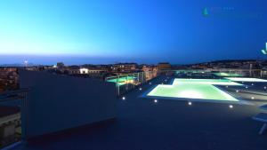 a view of a building with a tennis court on the roof at Alma di Alghero Hotel in Alghero