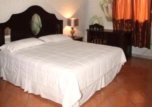 a bedroom with a large bed with a white comforter at Apart Hotel K-Lisma in San Pedro Sula