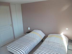 two beds sitting next to each other in a bedroom at Appartement au centre du tholy pour 5 personnes maximum in Le Tholy