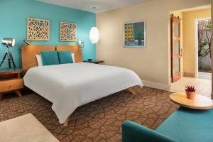 a bedroom with a large white bed and a couch at Movie Colony Hotel - Adults Only in Palm Springs