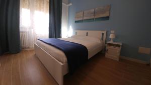 1 dormitorio con 1 cama con manta azul y ventana en Senigallia d'aMare, en Senigallia