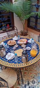 stół z niebieską i żółtą płytką żywności w obiekcie Riad Jbara w mieście Rabat
